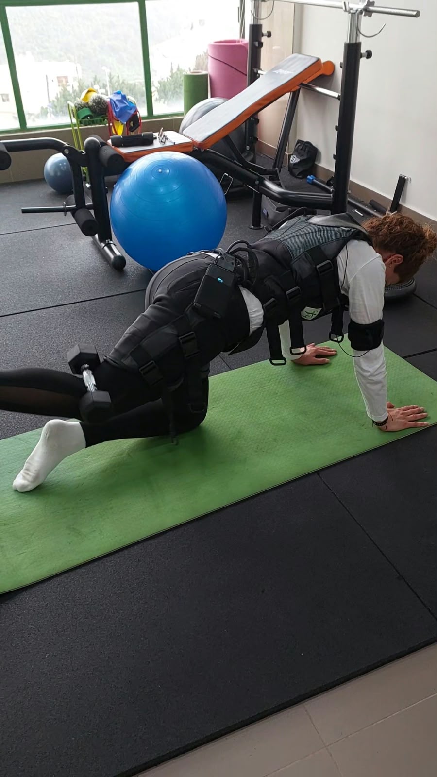 A client doing a floor exercise on a green mat